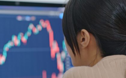 Woman looking at Forex charts on a computer