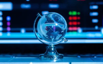 Globe in front of a forex trading screen